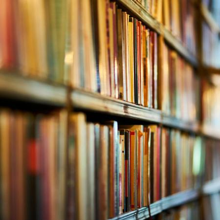 selective focus photography of brown wooden book shelf